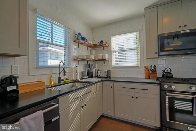 a kitchen with a sink stove top oven and microwave