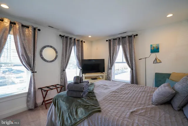 a bedroom with a bed and a large window