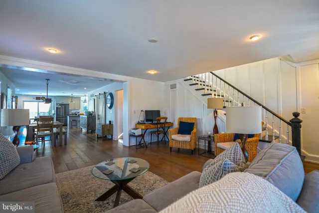a living room with furniture kitchen view and a large window