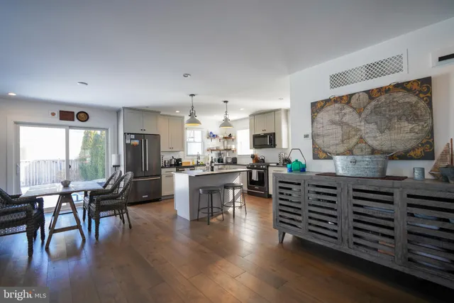 a living room with furniture a wooden floor and a large window