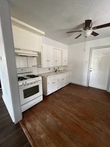 a kitchen with wooden floors and white appliances