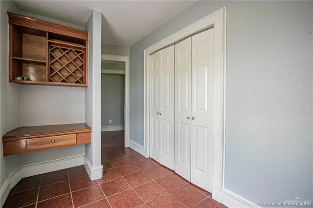 a view of a hallway with wooden floor and closet