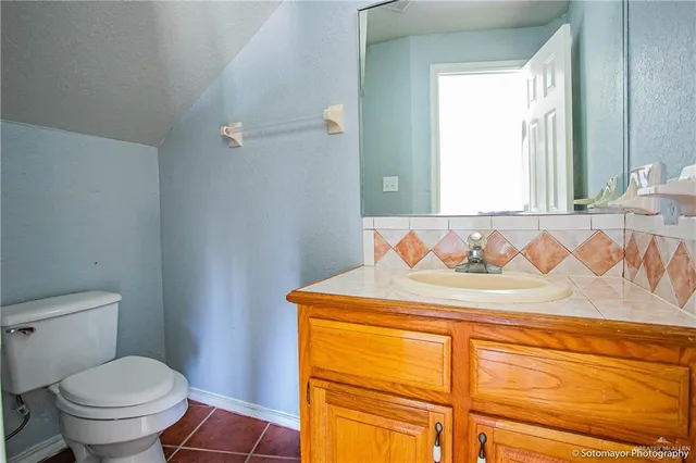 a bathroom with a granite countertop sink a toilet and a bathtub