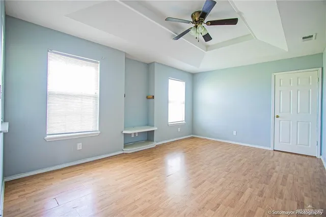 an empty room with fan and windows