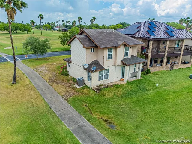 a aerial view of a house with a yard table and chairs
