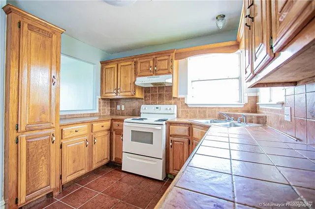 a kitchen with a stove a sink and a refrigerator