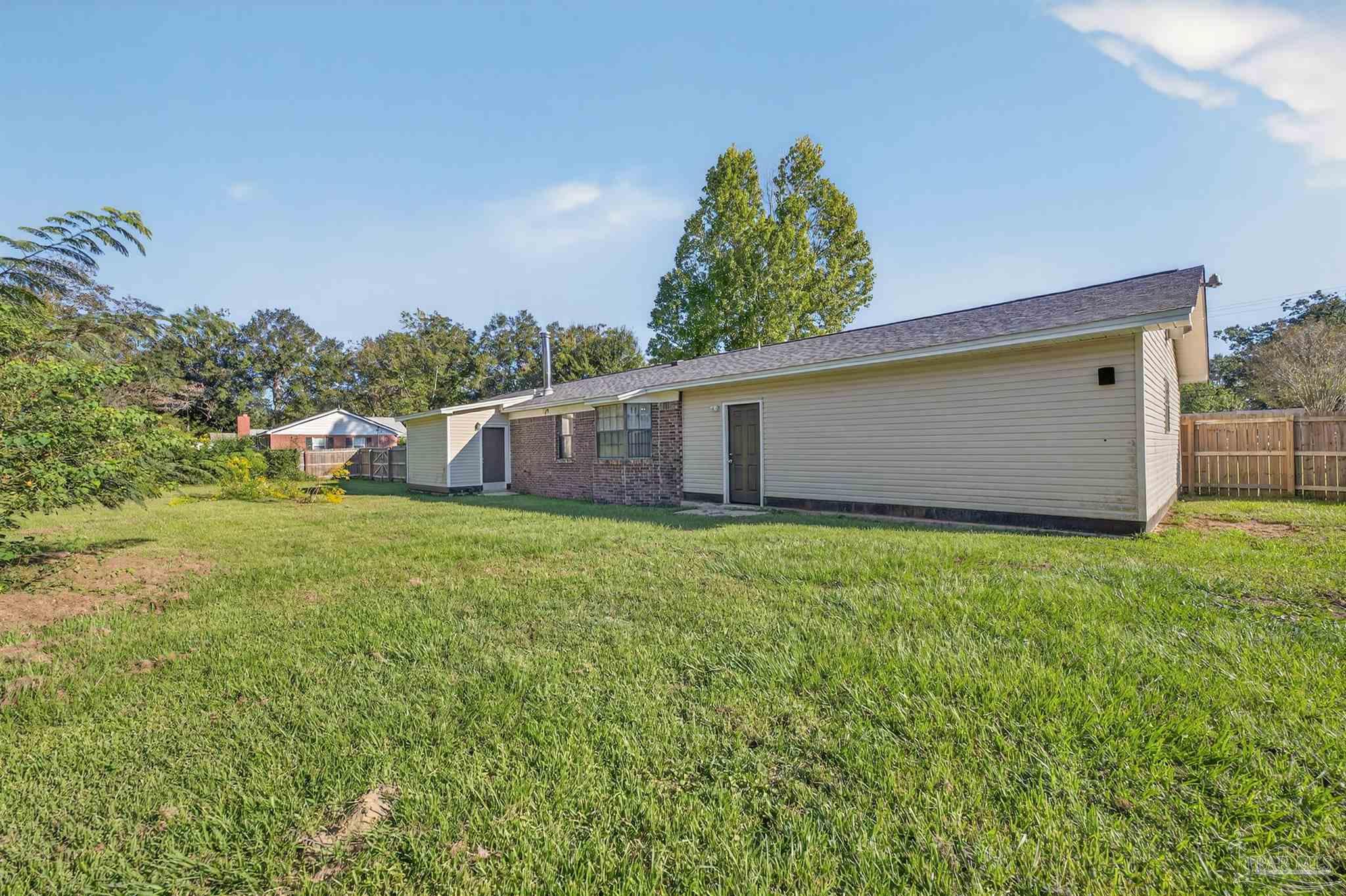 1120 Muscogee Road Cantonment, FL 32533 - Photo 26 of 38 a view of a backyard with a garden and plants