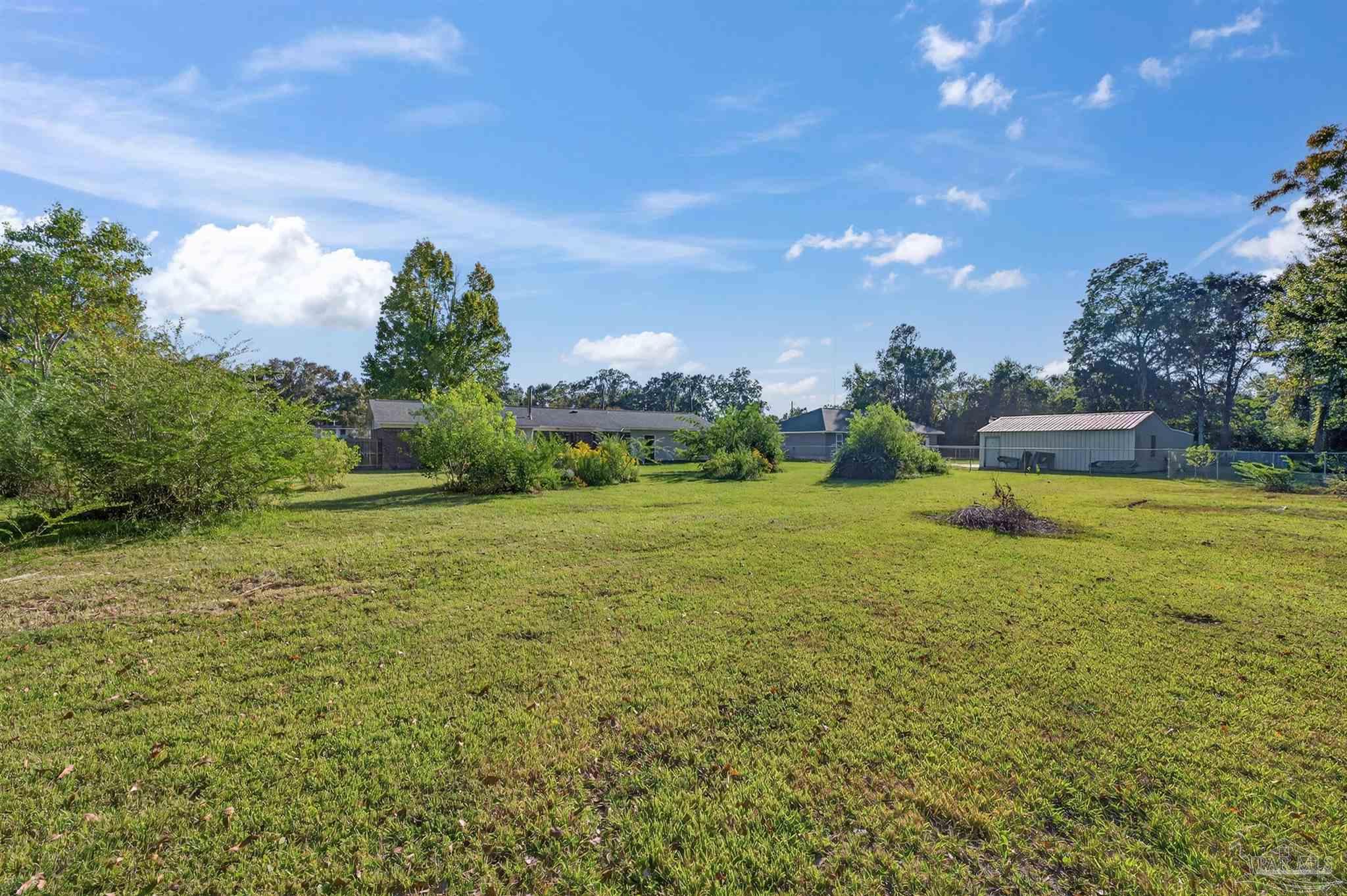 1120 Muscogee Road Cantonment, FL 32533 - Photo 32 of 38 a view of a garden with a building in the background