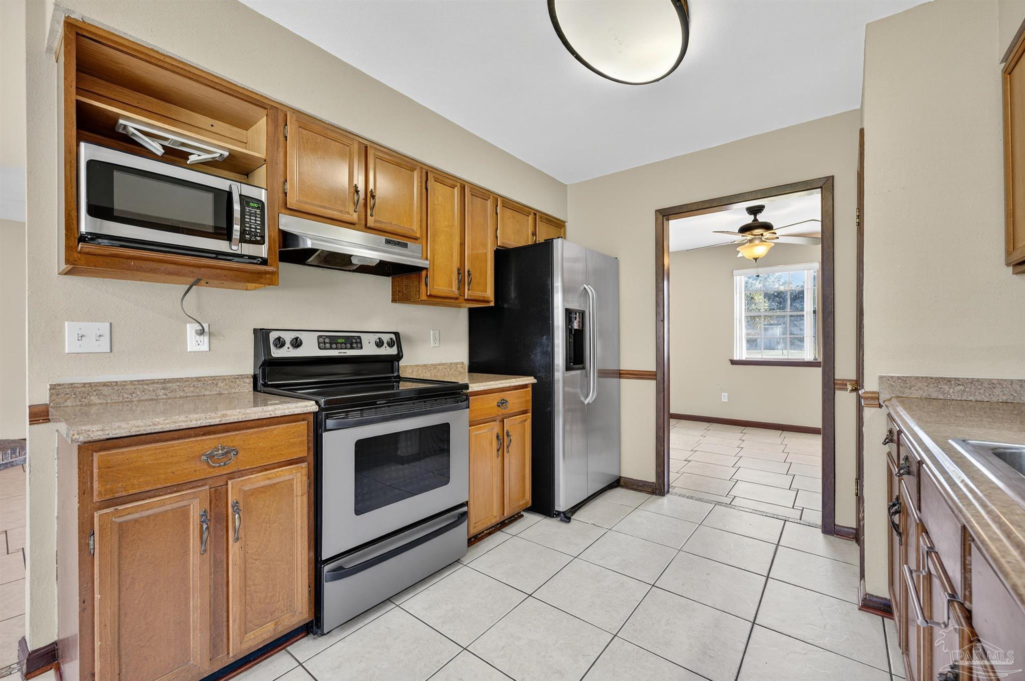 1120 Muscogee Road Cantonment, FL 32533 - Photo 5 of 38 a kitchen with stainless steel appliances granite countertop a stove and a microwave
