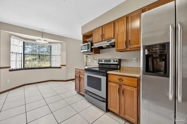 a kitchen with stainless steel appliances granite countertop a stove a sink and a refrigerator