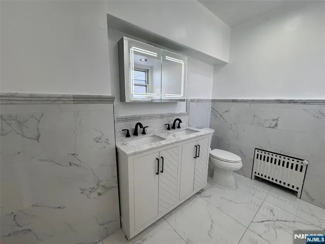 a bathroom with a sink a toilet and a mirror