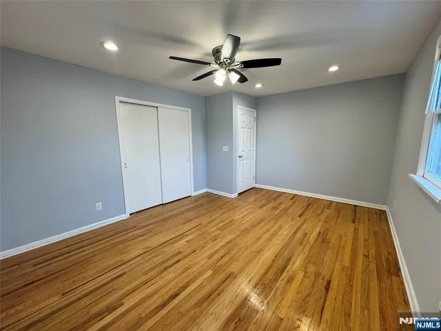 a view of a big room with wooden floor and fan