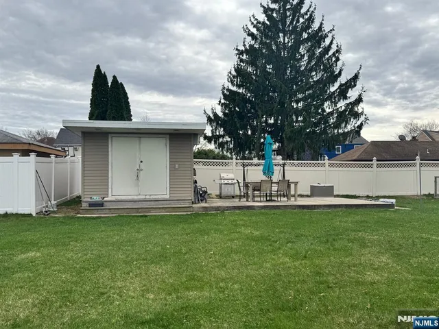 a view of a house with a yard and a large tree