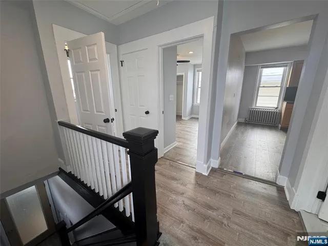 a view of a hallway with wooden floor and stairs