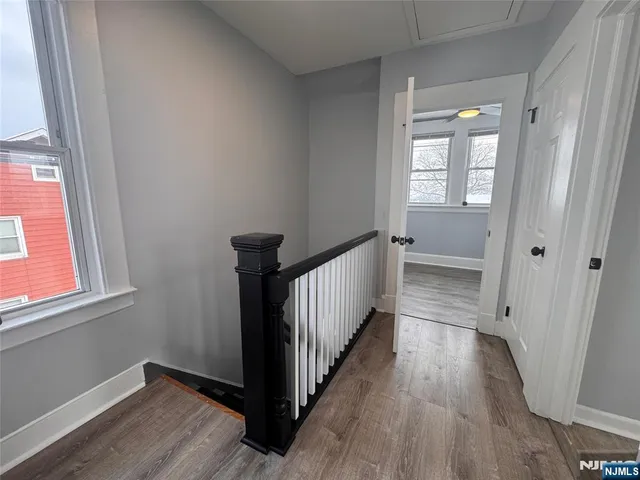 a view of a hallway with wooden floor and a window