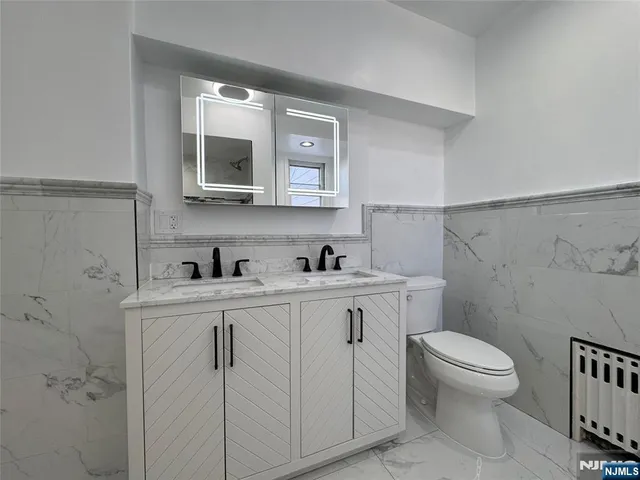 a bathroom with a sink a toilet and a mirror