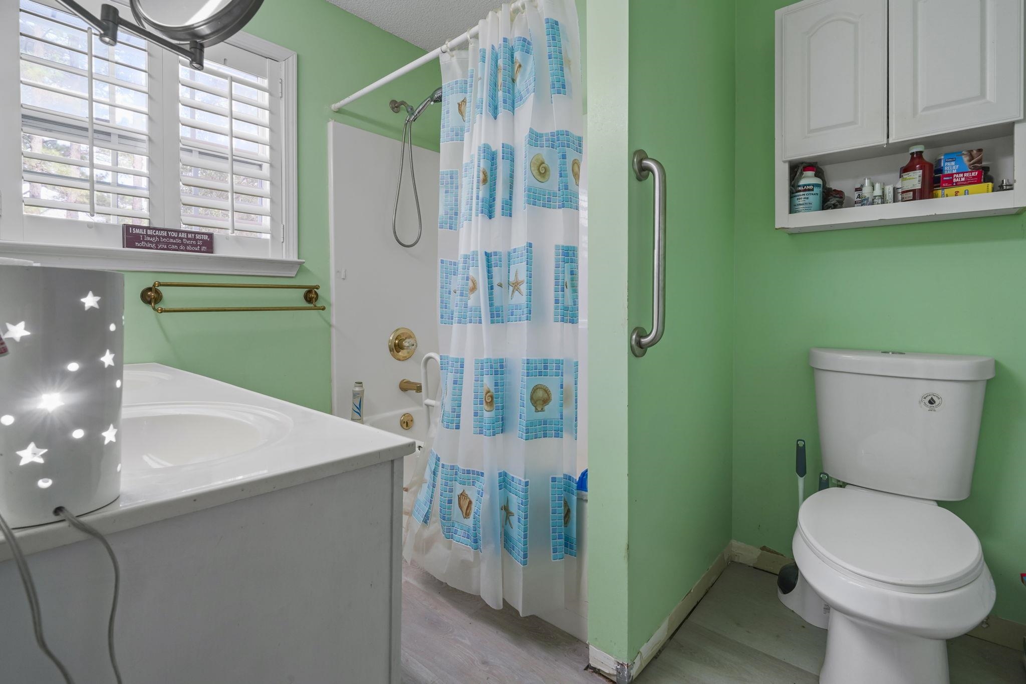 408 Rosemary Street Georgetown, SC 29440 - Photo 17 of 34 Full bathroom featuring curtained shower, vanity, and light wood-style flooring