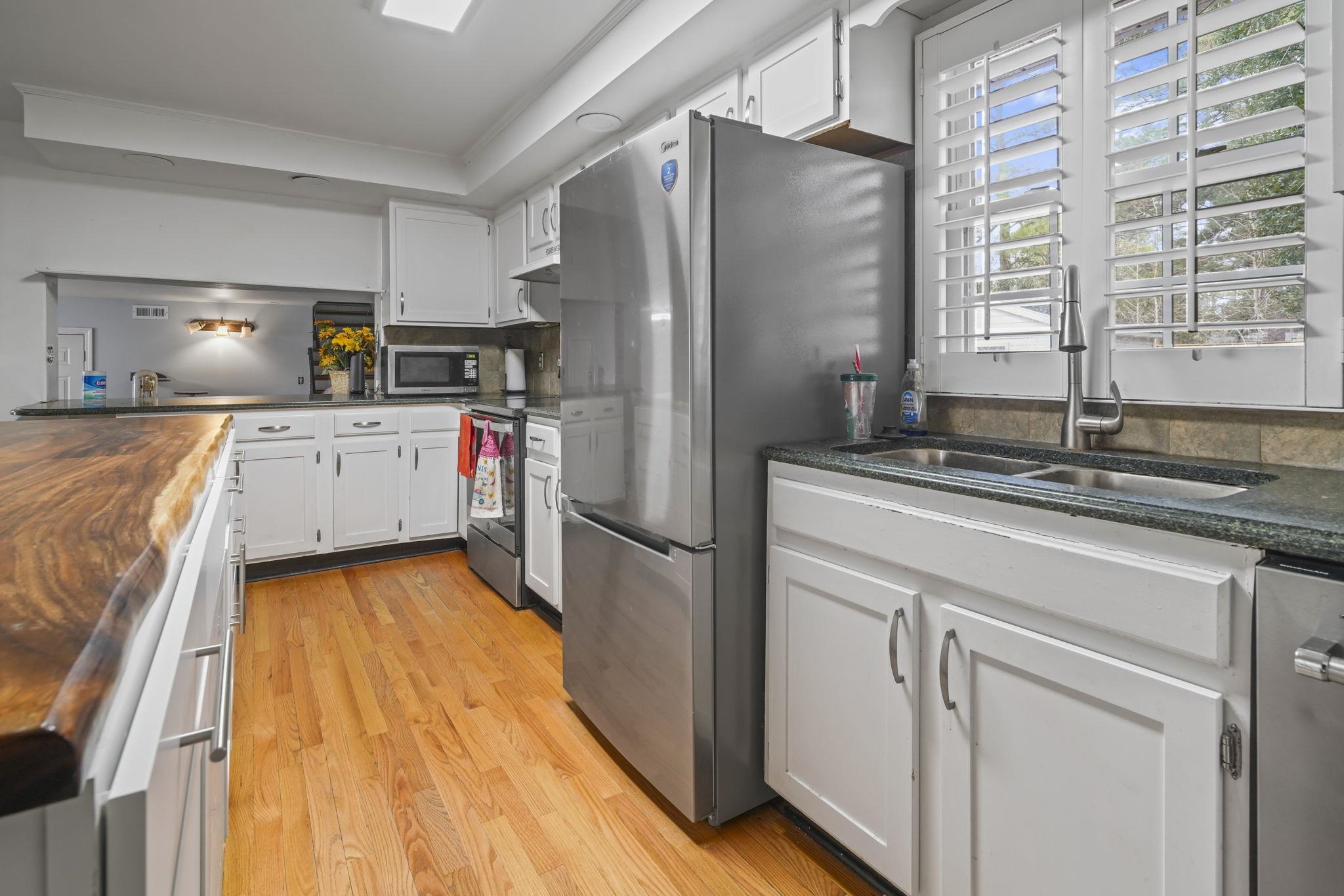 408 Rosemary Street Georgetown, SC 29440 - Photo 7 of 34 Kitchen with wooden counters, white cabinets, stainless steel appliances, light wood-type flooring, and a peninsula