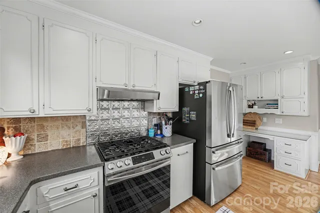 a kitchen with stainless steel appliances granite countertop a refrigerator stove and sink