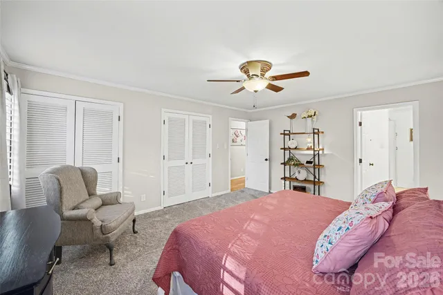a spacious bedroom with a bed a couch and a chandelier