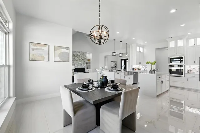 an open kitchen with granite countertop a stove and white cabinets