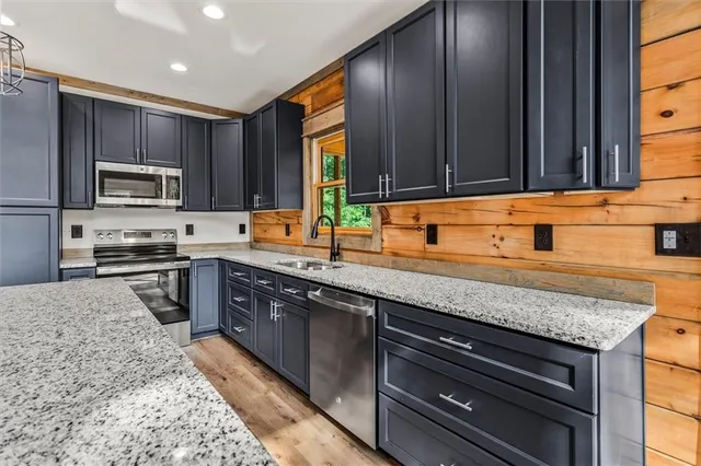 a kitchen with stainless steel appliances granite countertop a sink stove and microwave