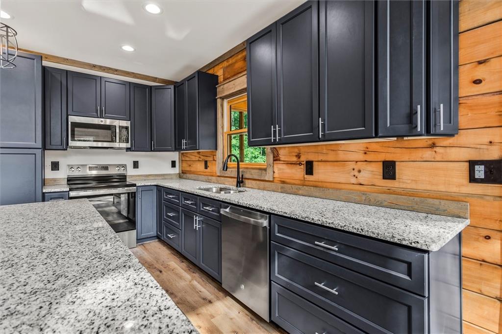 1725 Cherokee Gold Trail Ball Ground, GA 30107 - Photo 12 of 57 a kitchen with stainless steel appliances granite countertop a sink stove and microwave