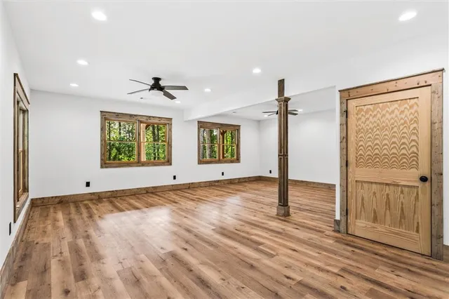 an empty room with wooden floor cabinet and front door
