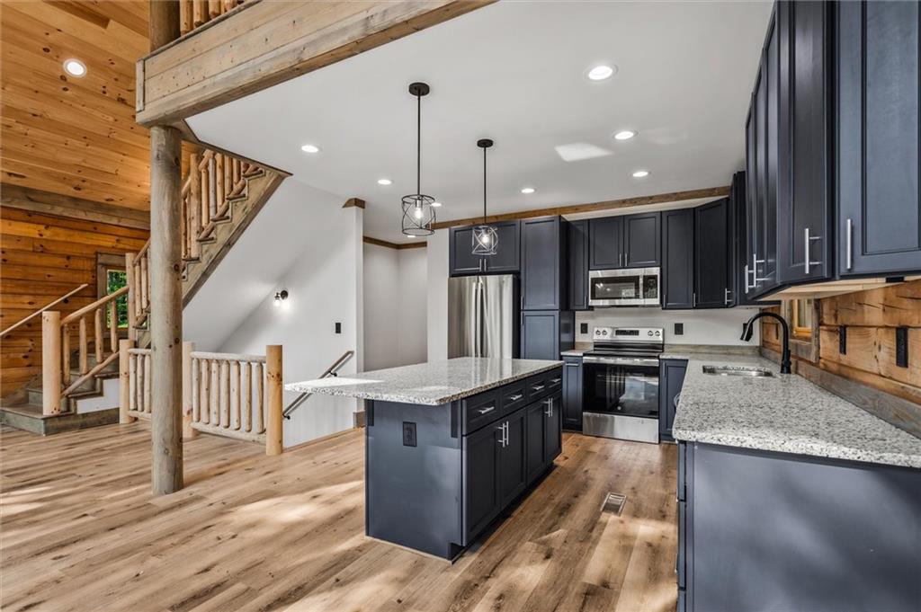 1725 Cherokee Gold Trail Ball Ground, GA 30107 - Photo 10 of 57 a large kitchen with stainless steel appliances granite countertop a stove and a wooden cabinets