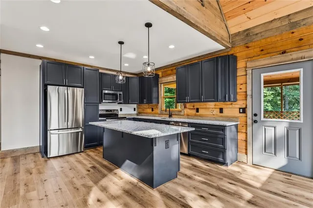 a kitchen with stainless steel appliances granite countertop a stove refrigerator and cabinets