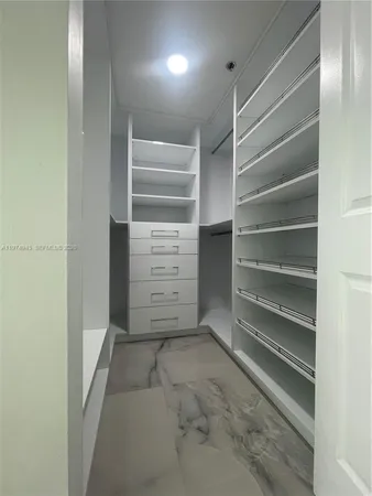 a view of walk in closet with empty racks