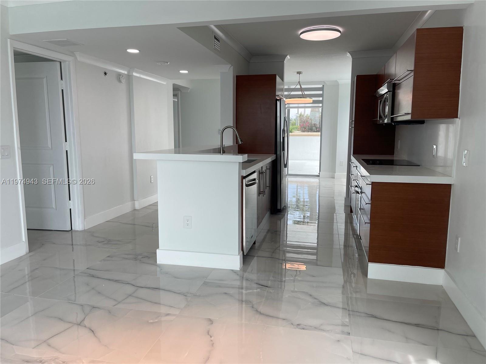 2681 North Flamingo Road, Unit 401S Sunrise, FL 33323 - Photo 16 of 18 a kitchen with kitchen island cabinets and refrigerator