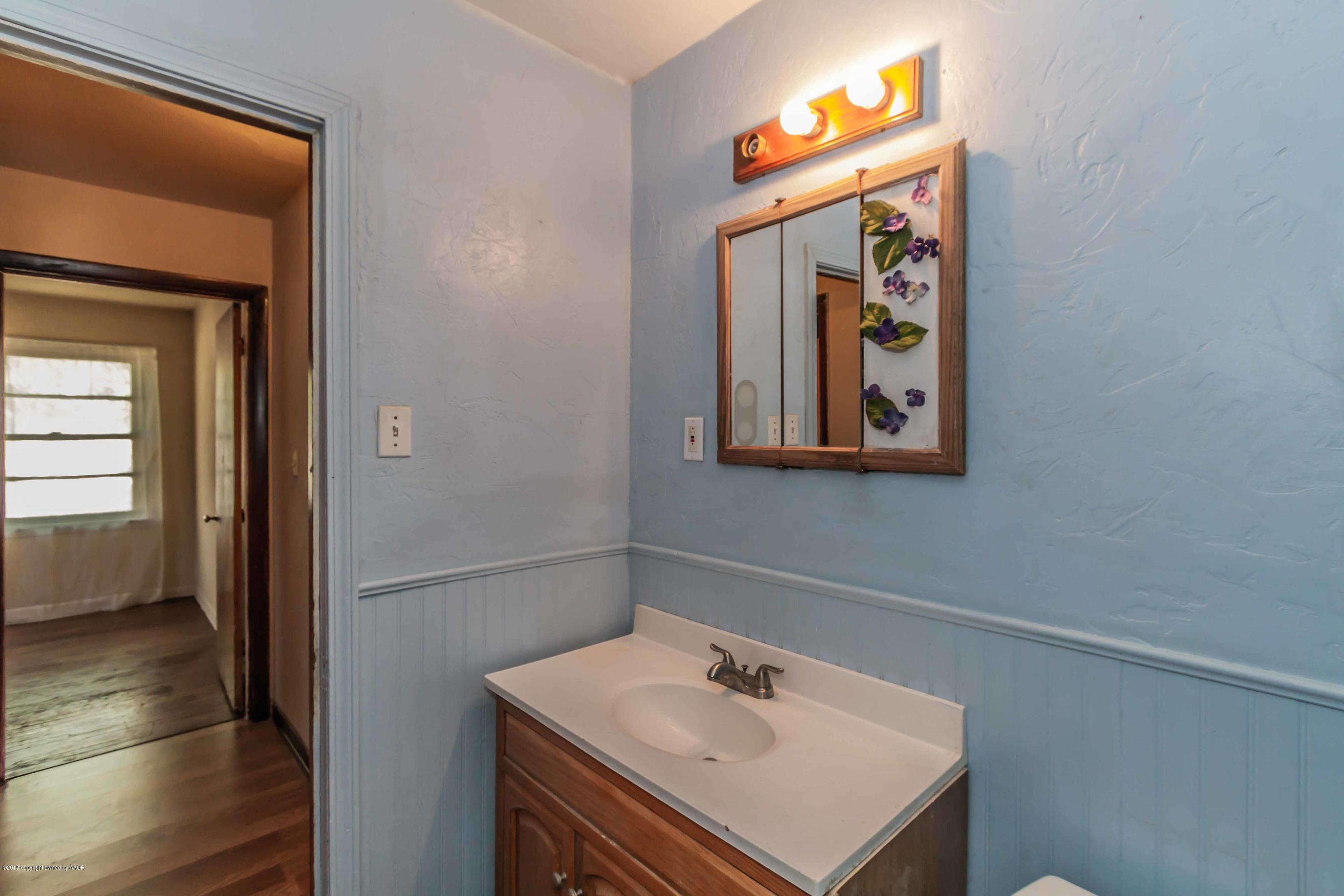 4307 Gables Street Amarillo, TX 79110 - Photo 14 of 32 a bathroom with a sink mirror and vanity