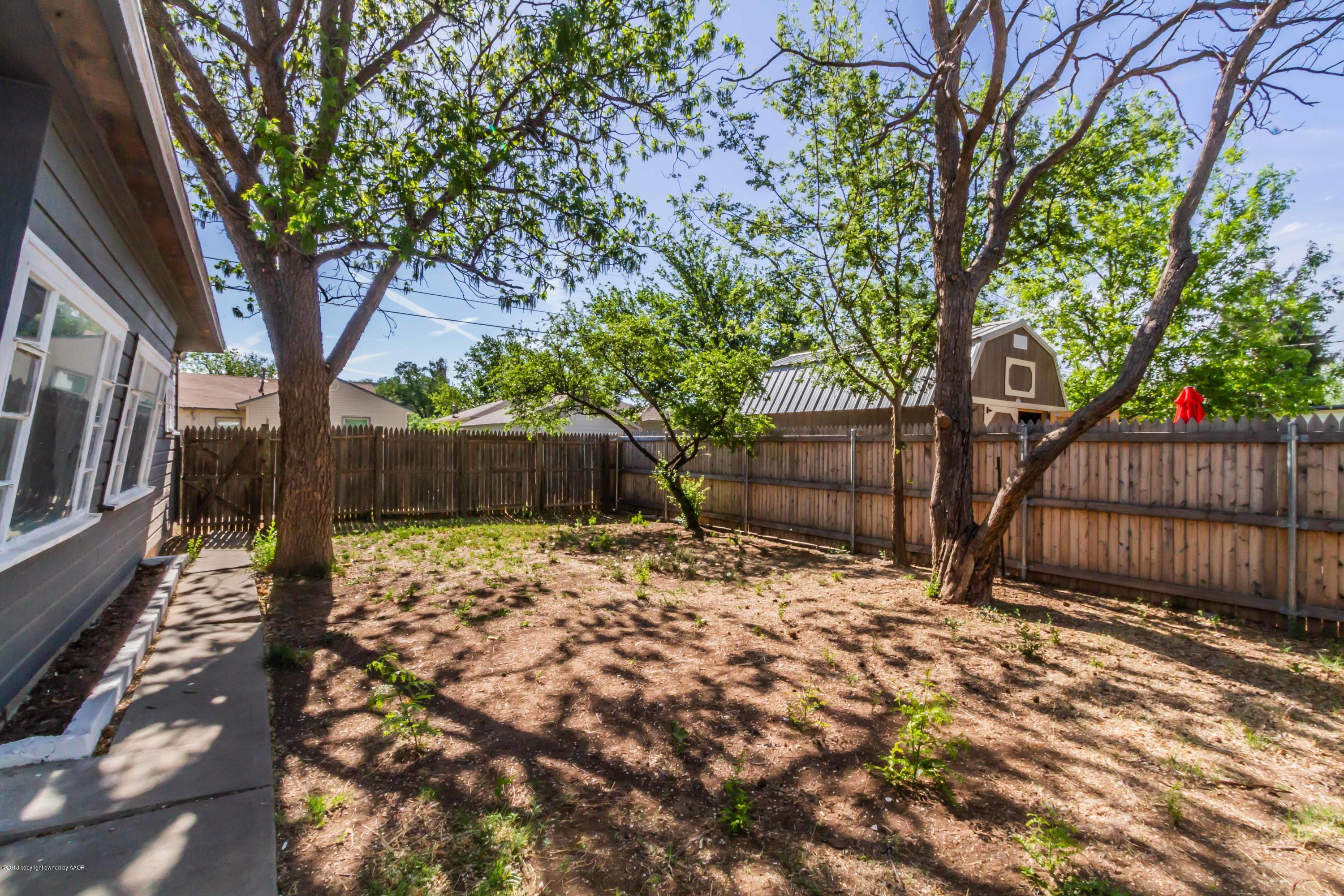 4307 Gables Street Amarillo, TX 79110 - Photo 30 of 32 a view of a backyard with wooden fence and a large tree