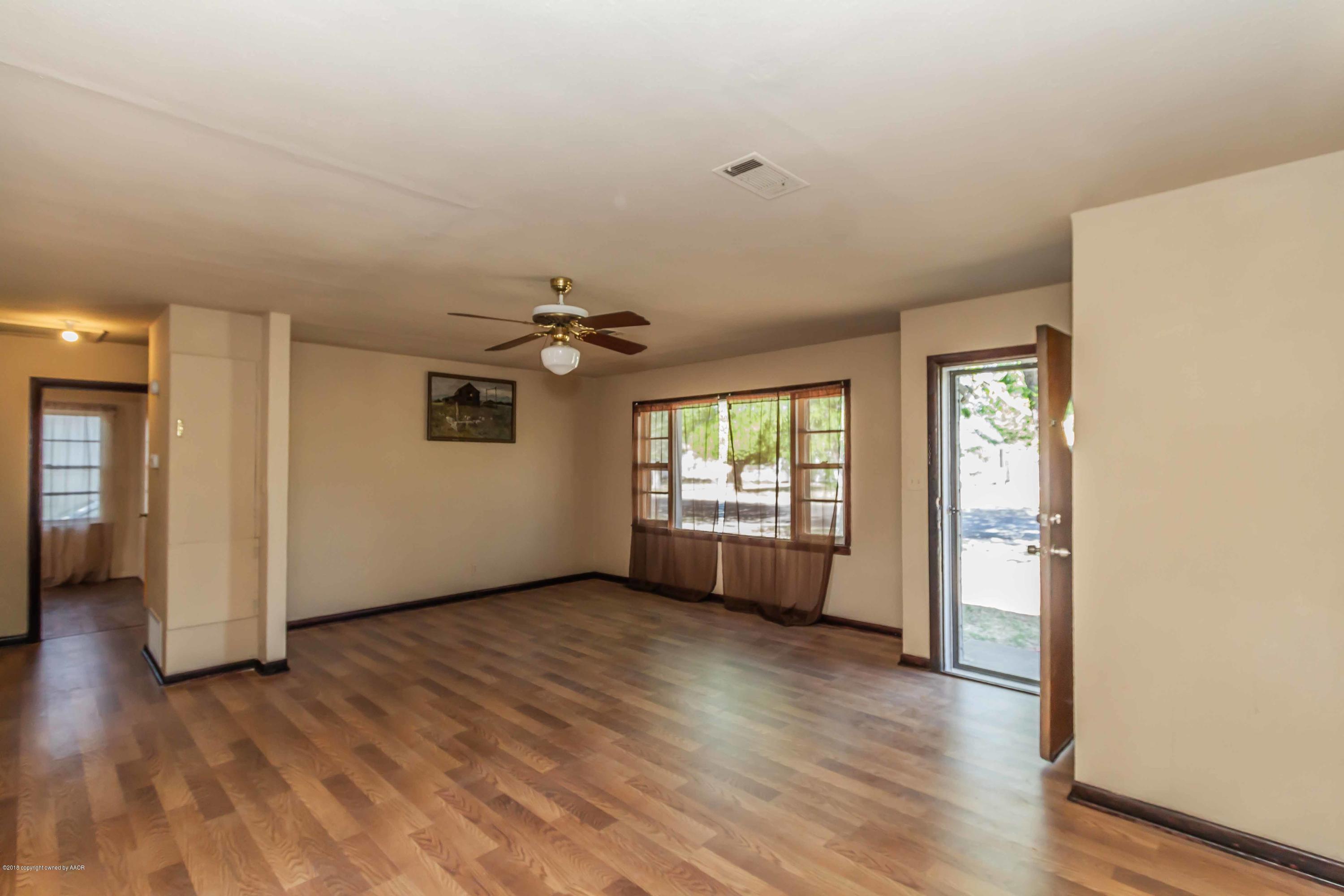 4307 Gables Street Amarillo, TX 79110 - Photo 6 of 32 a view of an empty room with a window and wooden floor
