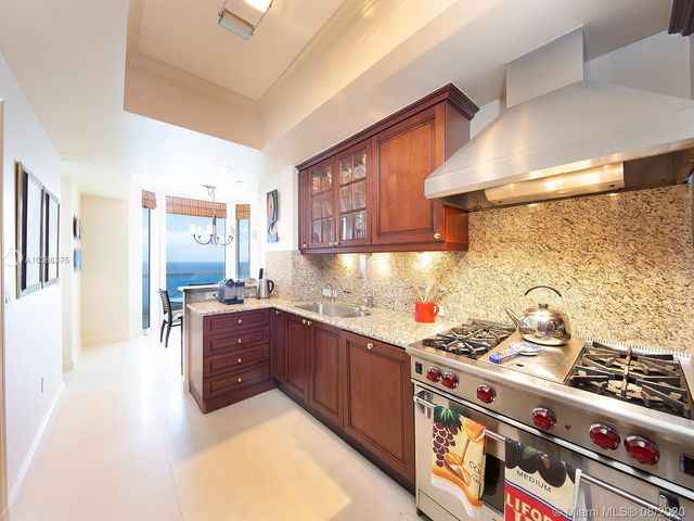 a kitchen with granite countertop a stove and cabinets
