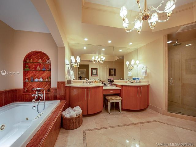 a large living room with granite countertop furniture a chandelier fan and a bath tub