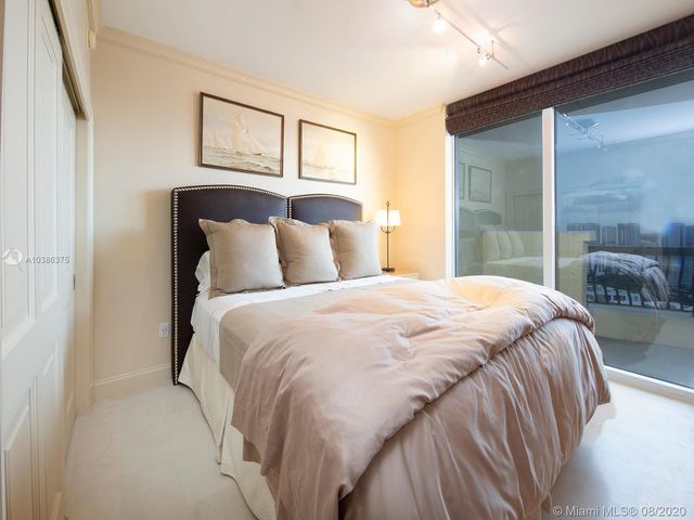 a bedroom with a bed and a large mirror