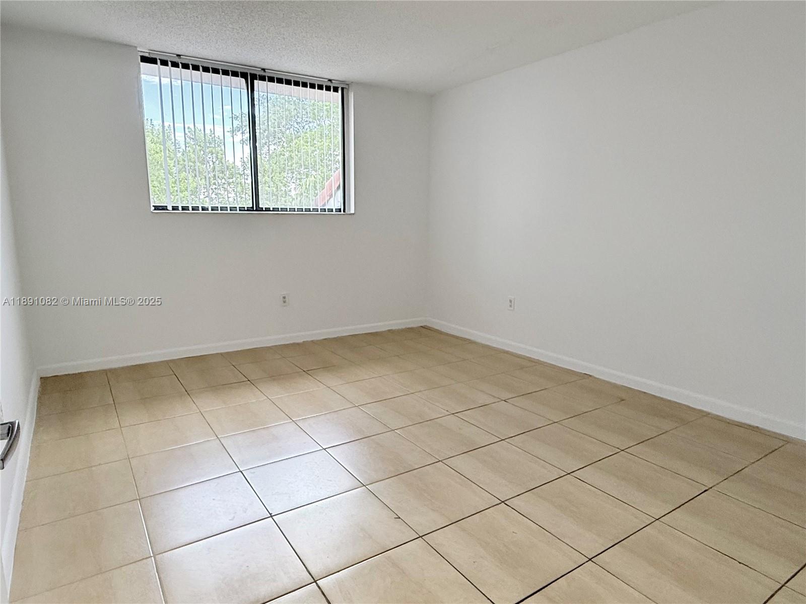 8275 Southwest 152nd Avenue, Unit D408 Miami, FL 33193 - Photo 8 of 9 an empty room with a window