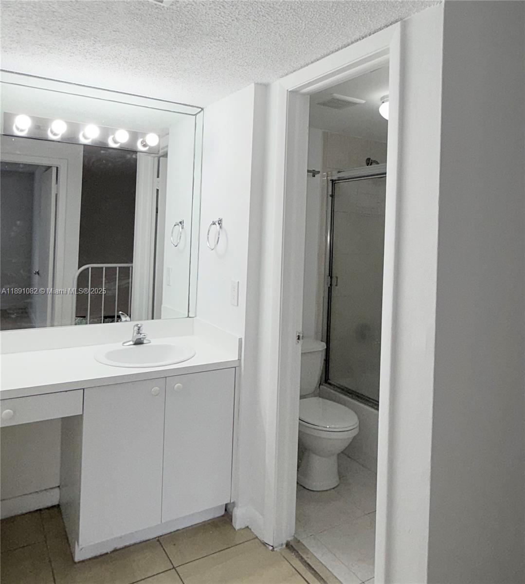 8275 Southwest 152nd Avenue, Unit D408 Miami, FL 33193 - Photo 9 of 9 a bathroom with a toilet sink and mirror