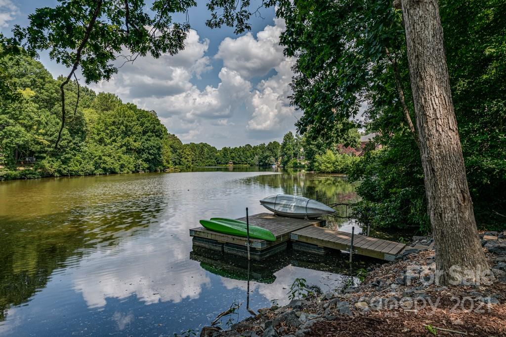 150 Canterbury Crossing Fort Mill, SC 29708 - Photo 2 of 48 a view of a lake with lawn chairs and a large tree