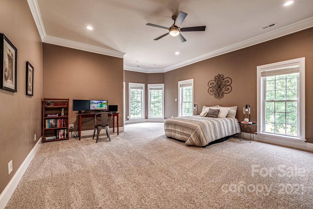 150 Canterbury Crossing Fort Mill, SC 29708 - Photo 31 of 48 a spacious bedroom with a bed a table and a chandelier