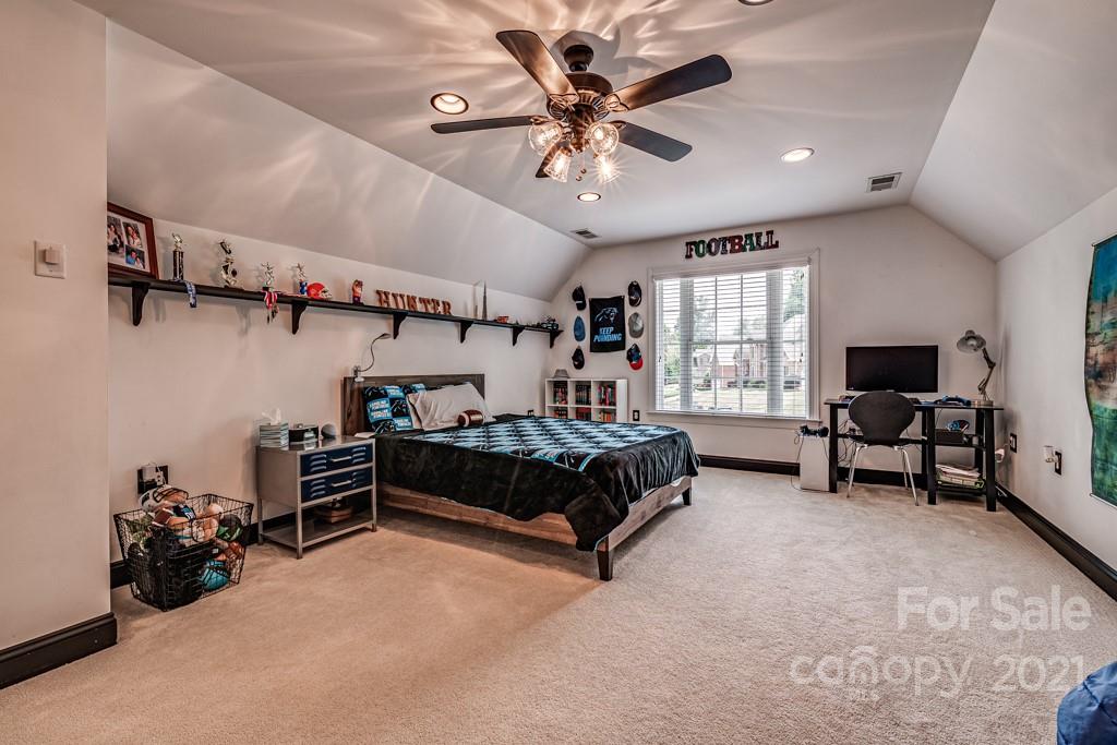 150 Canterbury Crossing Fort Mill, SC 29708 - Photo 33 of 48 a bedroom with a bed and a chandelier