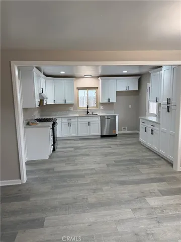 a large kitchen with cabinets and wooden floor