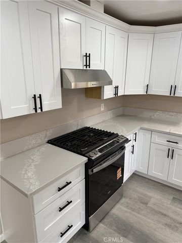 a kitchen with white cabinets and appliances