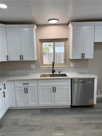 a kitchen with granite countertop white cabinets and white appliances