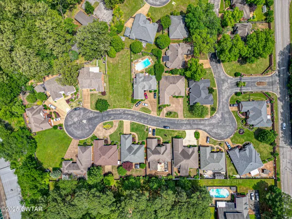 an aerial view of residential houses with outdoor space and parking