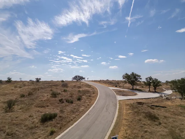 a view of a dry yard with wooden fence