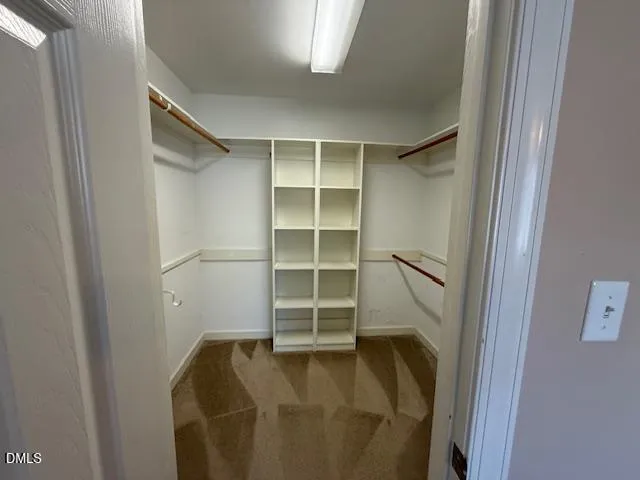a view of walk in closet with empty racks