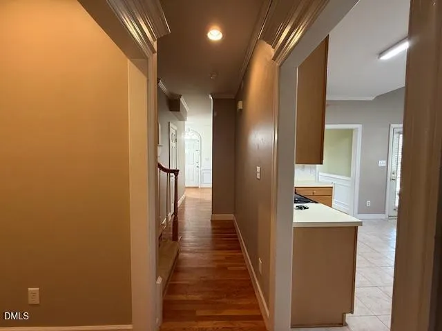 a view of a hallway with wooden floor and a bathroom